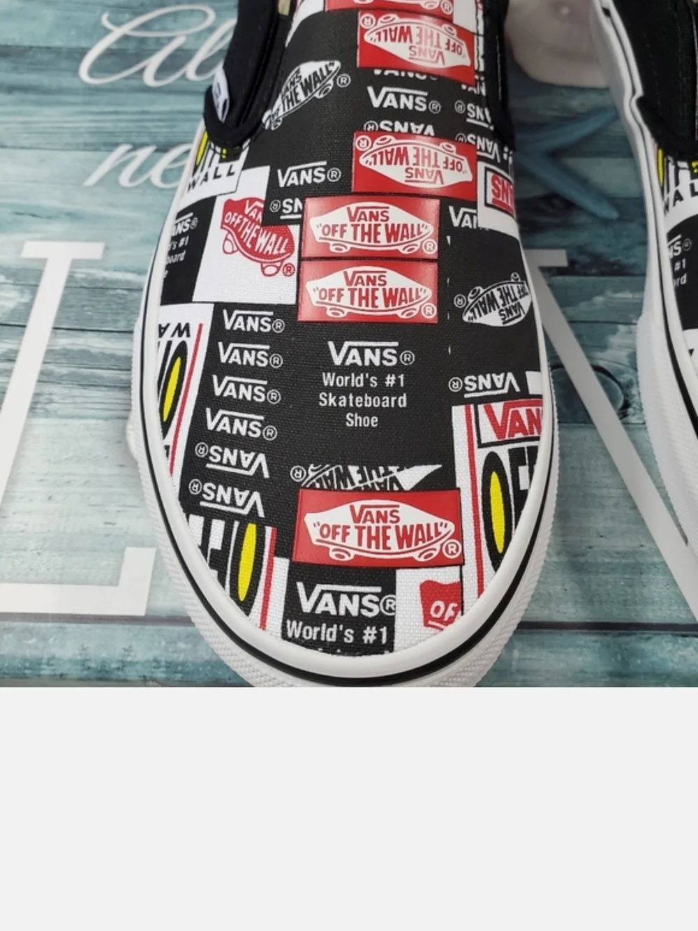 Vans Black Slip-On Sneakers with Red, White & Yellow Logo Print